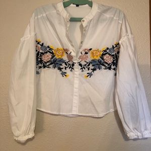 Long sleeve blouse crop top with design on front.